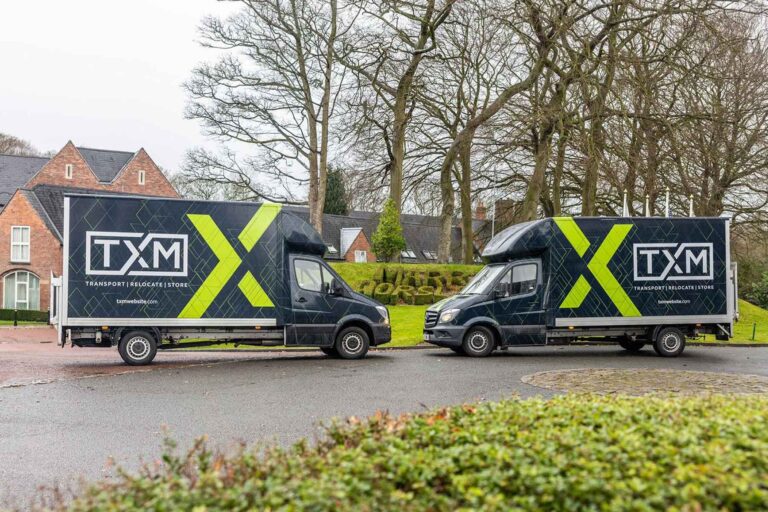 TXM removals vans parked nose to nose at a house move in Manchester