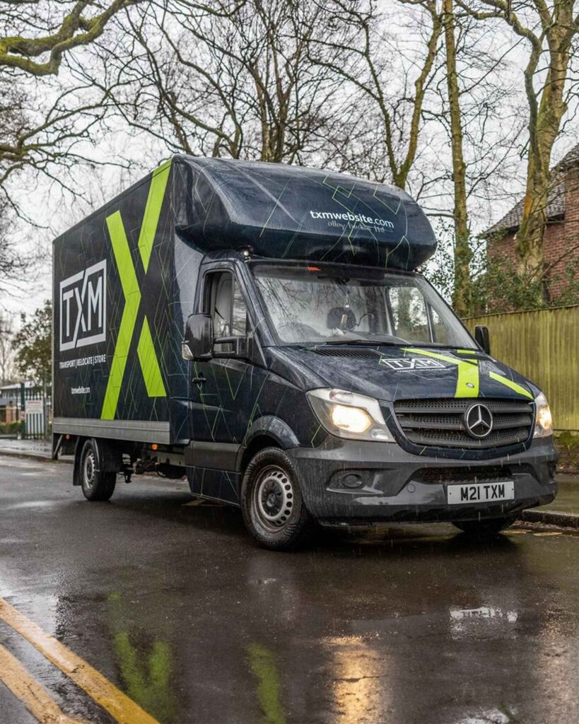 TXM removals vans at a house move in Urmston